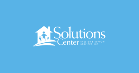 Solutions Center Shelter and Support Services logo on light blue background.